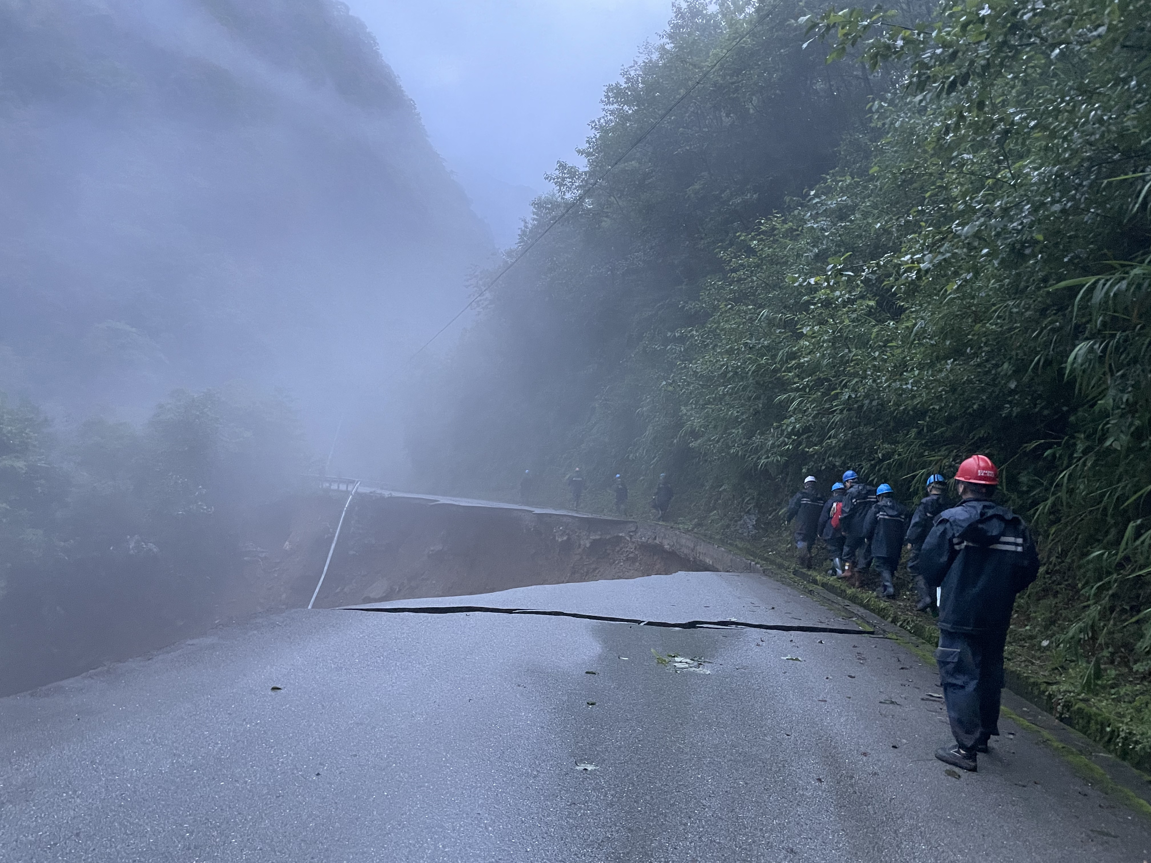 电力抢修人员通过塌方路段。.jpg